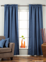 Blue raw silk rod pocket curtains hung at a window