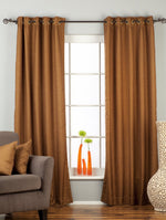 Brown raw silk ring top curtains hung at a window