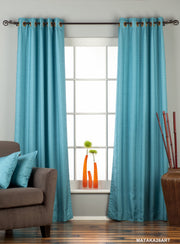 Turquoise raw silk ring top curtains hung at a window