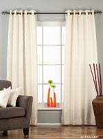 Cream raw silk ring top curtains hung at a window
