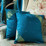 Turquoise sari cushion covers arranged on a sofa