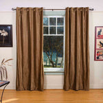 Taupe velvet grommet top curtains hung at a window