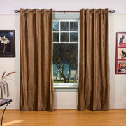Taupe velvet grommet top curtains hung at a window