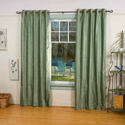 Olive green velvet grommet top curtains hung at a window