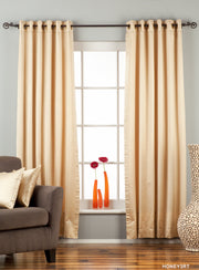Golden sari grommet top curtains hung at a window