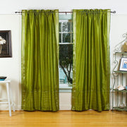 Olive green sari rod pocket curtains hung at a window