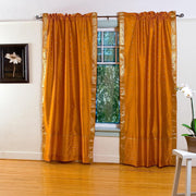 Mustard sari rod pocket curtains hung at a window