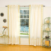 Cream sari rod pocket curtains hung at a window