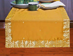Earthy mustard silk table runner running down a dining table