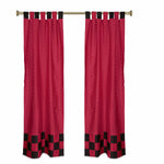 Red sari tab top curtains hung at a window