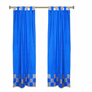 Coral sari tab top curtains hung at a window