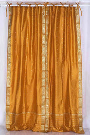 Mustard sari tie top curtains hung at a window