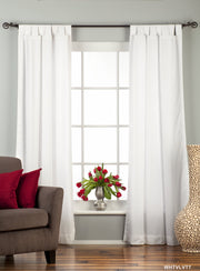 White velvet tab top curtains hung at a window