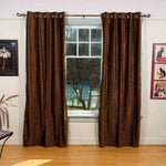 Brown velvet grommet top curtains hung at a window