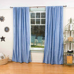 Light blue velvet rod pocket curtains hung at a window