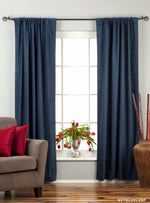 Navy blue velvet rod pocket curtains hung at a window