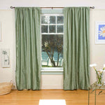 Olive green velvet rod pocket curtains hung at a window