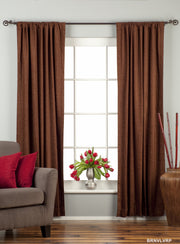 Brown velvet rod pocket curtains hung at a window