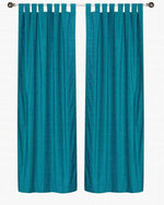 Turquoise velvet tab top curtains hung at a window