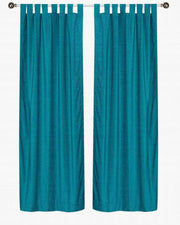 Turquoise velvet tab top curtains hung at a window