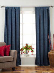 Navy blue velvet tab top curtains hung at a window