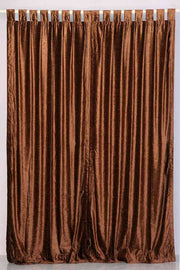 Brown velvet tab top curtains hung at a window