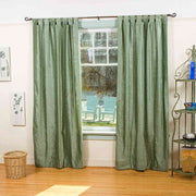 Olive green velvet tab top curtains hung at a window