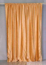 Peach velvet rod pocket curtains hung at a window