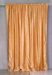 Peach velvet rod pocket curtains hung at a window