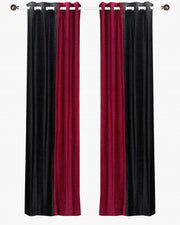 Burgundy velvet ring top curtains hung at a window