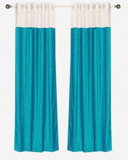 Turquoise velvet ring top curtains hung at a window