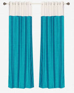Turquoise velvet ring top curtains hung at a window