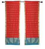 Red sari rod pocket curtains hung at a window