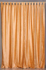 Peach velvet tab top curtains hung at a window