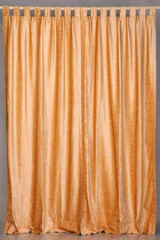 Peach velvet tab top curtains hung at a window