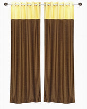 Yellow velvet ring top curtains hung at a window