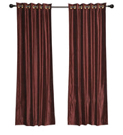 Wine velvet grommet top curtains hung at a window