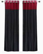 Burgundy velvet ring top curtains hung at a window