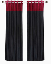 Burgundy velvet ring top curtains hung at a window