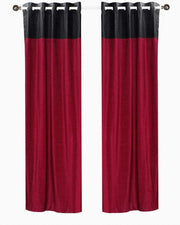 Burgundy velvet ring top curtains hung at a window