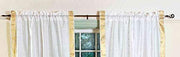 White sari rod pocket curtains hung at a window