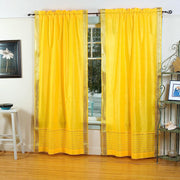 Yellow sari rod pocket curtains hung at a window