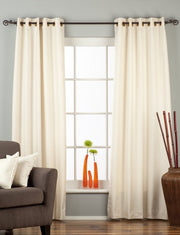 Cream raw silk ring top curtains hung at a window