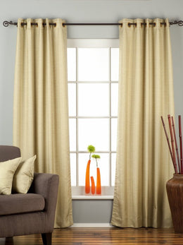 Olive green raw silk grommet top curtains hung at a window