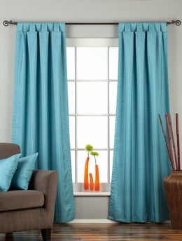 Turquoise raw silk tab top curtains hung at a window
