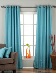 Turquoise raw silk ring top curtains hung at a window