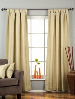 Olive green raw silk tab top curtains hung at a window