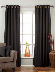 Black raw silk grommet top curtains hung at a window