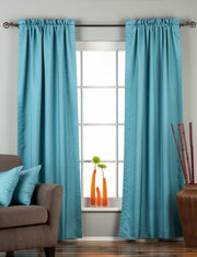 Turquoise raw silk rod pocket curtains hung at a window
