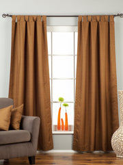 Brown raw silk tab top curtains hung at a window